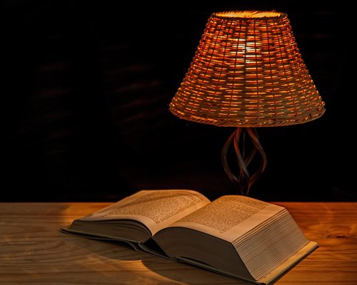 A warm desk lamp illuminating an open book
